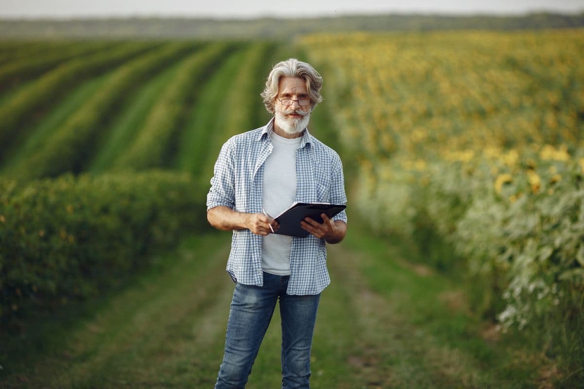 Farmer standing in a field holding a tablet